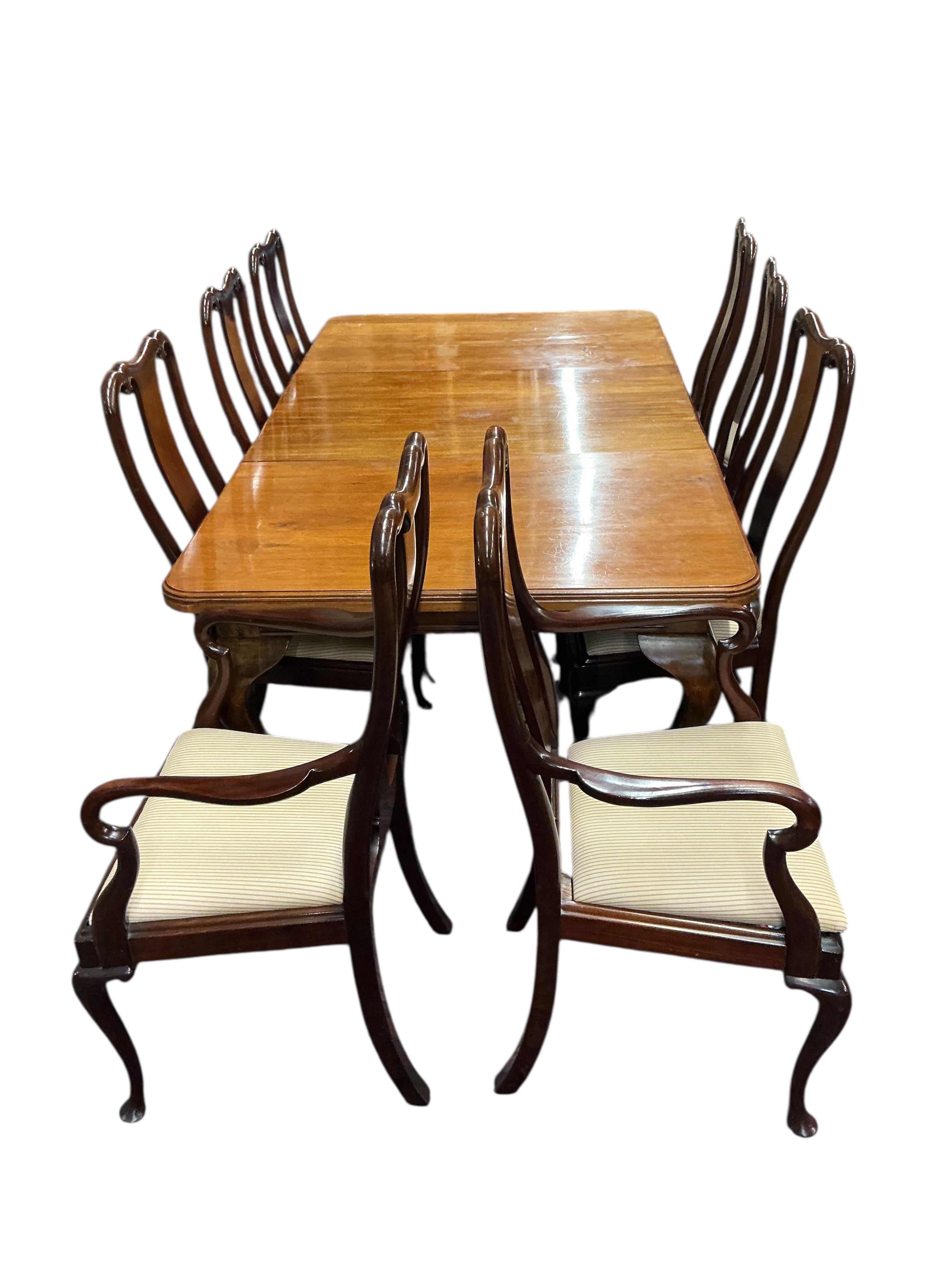 A 1920's mahogany extending dining table 206cm extended, one spare leaf, and eight Queen Anne style mahogany dining chairs, two with arms